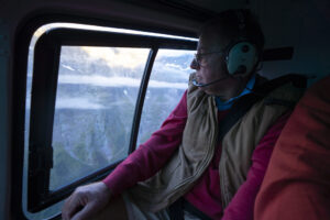 Man looking out window of a helicopter